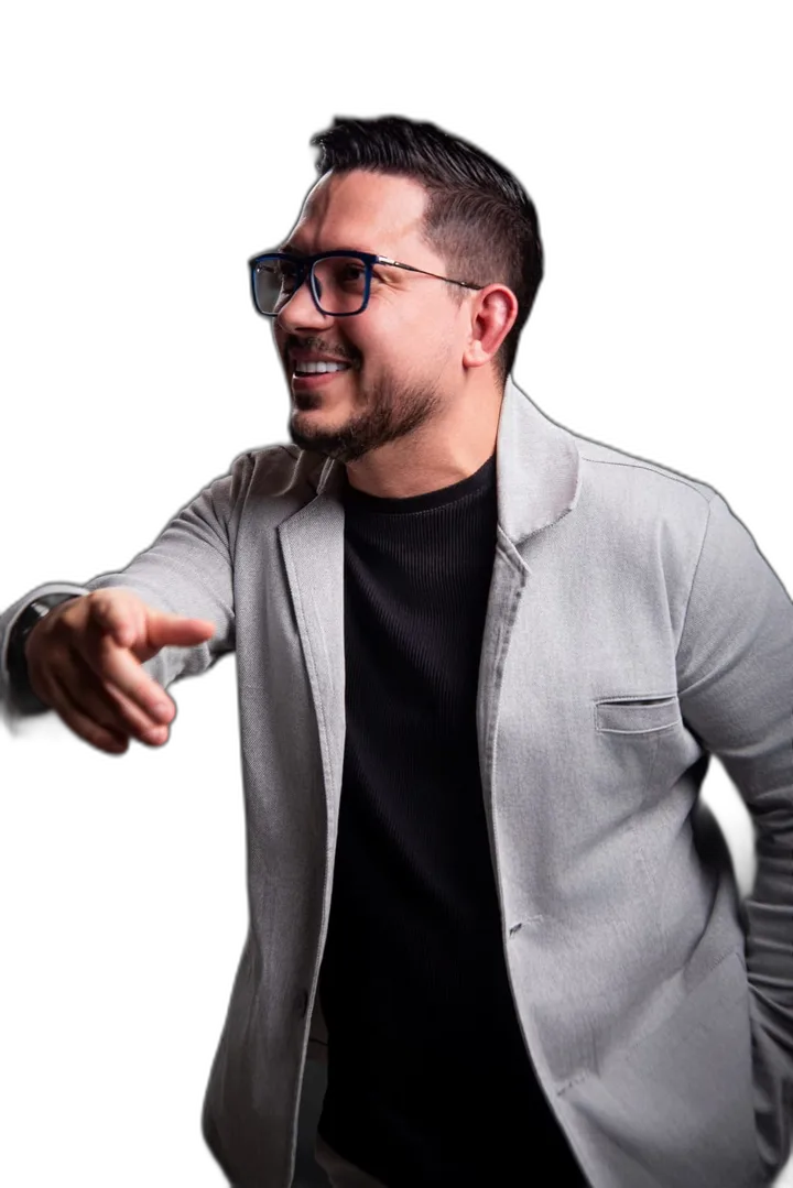 Guedes Digital, sócio da AdScout Digital, de óculos e paletó cinza, sorrindo e apontando